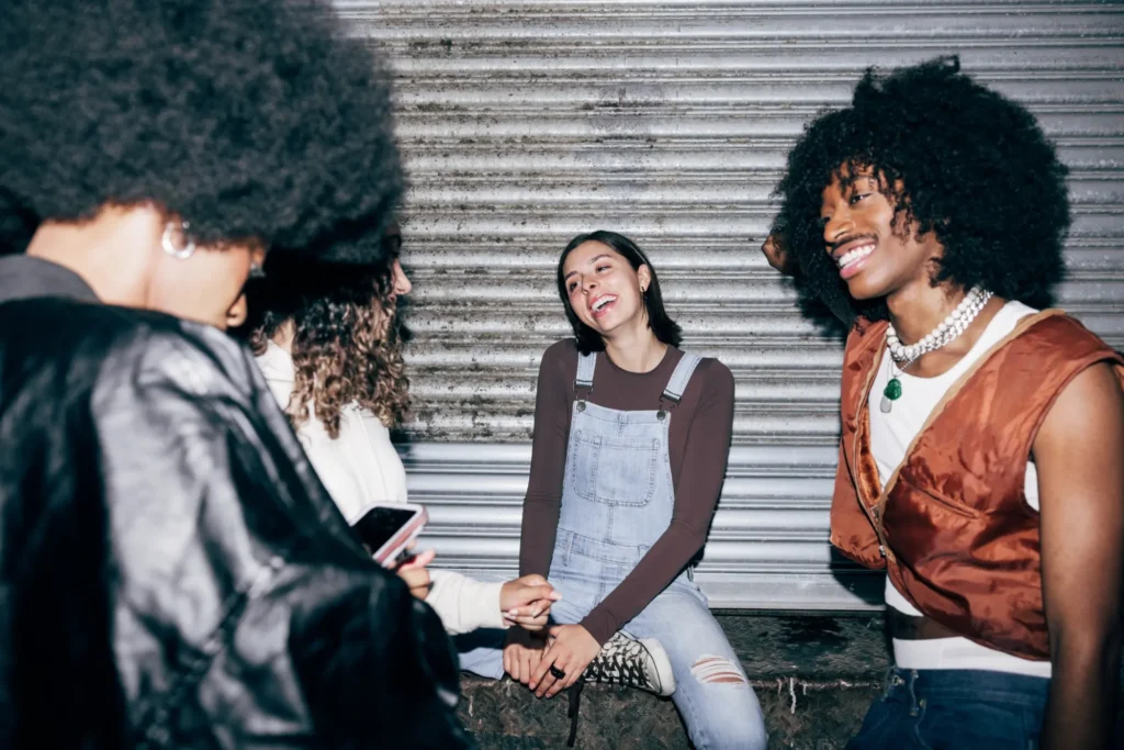 Group of friends laughing together during an indie-inspired night out in downtown Napa with candid late-night energy.