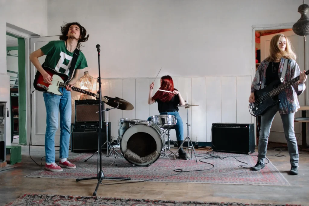 Napa rock band performing together during a live music jam session with guitars and drums in a creative studio space.